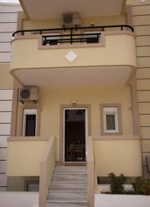 a building with stairs leading up to a door at Sunny Apartments in Makry Gialos