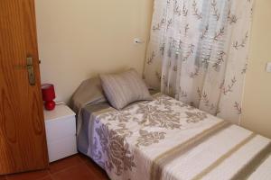 プラゼーレスにあるParadise in Prazeresの小さなベッドルーム(ベッド1台、窓付)