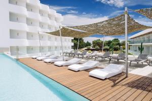 una fila de tumbonas junto a una piscina en Inturotel Cala Esmeralda Beach Hotel & Spa - Adults Only en Cala d´Or