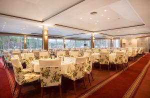 un salón de banquetes con mesas y sillas blancas en Lycus River Thermal Hotel en Pamukkale