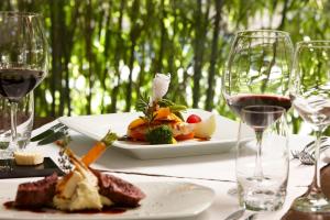 a table with a plate of food and wine glasses at Hotel Restaurant Rössli in Bad Ragaz