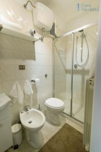 uma casa de banho com um chuveiro, um WC e um lavatório. em Casa Nicoletta em Noci