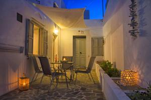 a patio with chairs and a table at night at Lindos Tholos Villa in Lindos