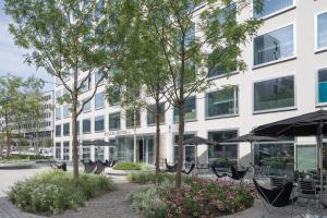 um edifício com mesas e guarda-chuvas à sua frente em Placid Hotel Design & Lifestyle Zurich em Zurique