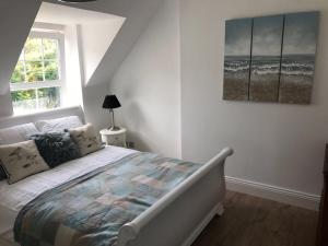a bedroom with a bed and a painting on the wall at 5, Sandleigh Apartment in Woolacombe