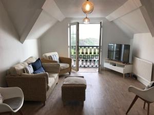 a living room with two couches and a television at 5, Sandleigh Apartment in Woolacombe