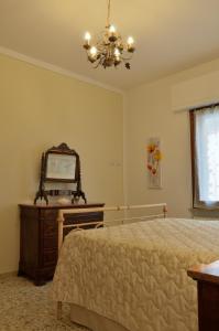 サン・カシャーノ・イン・ヴァル・ディ・ペーザにあるLa Casa di'Grilloのベッドルーム1室(ベッド1台、鏡付きドレッサー付)