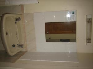 ein Badezimmer mit einem Urinal, einem Waschbecken und einem Spiegel in der Unterkunft Murrayfield Park Guest House in Edinburgh