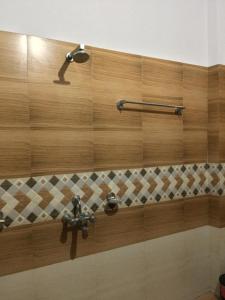 a bathroom with a wooden wall with two faucets at Senamura Yoga Ashram Guesthouse in Bodh Gaya +74 photos