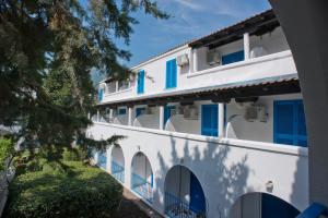 a white building with blue shutters on it at Hotel Aleksandar in Budva