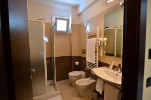 
a bathroom with a toilet, sink, and shower at Hotel I Crespi in Grosseto
