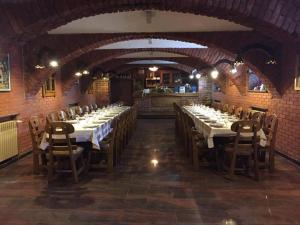 uma grande sala de jantar com mesas longas e cadeiras em Business Club em Slatina