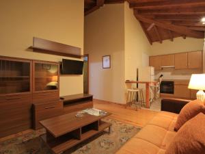 ein Wohnzimmer mit einem Sofa und einem Flachbild-TV in der Unterkunft El Puentín del Sella con WiFi y parking gratuito in Cangas de Onís