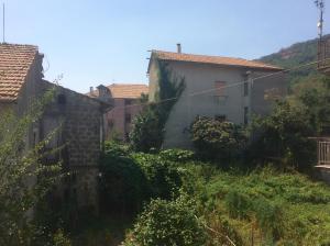 un gruppo di edifici su una collina con erba di Gli dei e le Rose ad Agerola