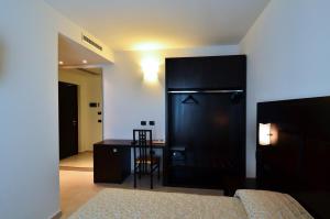 a bedroom with a bed and a desk and a chair at Hotel I Crespi in Grosseto