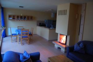 a living room with a fireplace and a table at Ferien im Gutspark Schwarbe mit Re in Mattchow