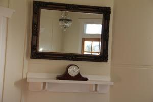 a clock on a wall in a bathroom at Mentor Chambers Apartment Bed & Breakfast in West Wyalong