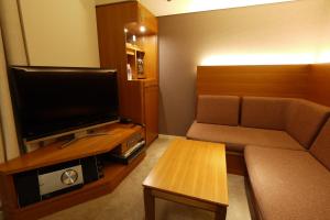 a small living room with a couch and a television at Shibuya Granbell Hotel in Tokyo