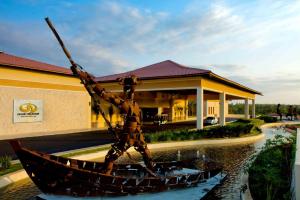 a boat in the water in front of a building at Grand Palladium Imbassaí Resort & Spa - All Inclusive in Imbassai