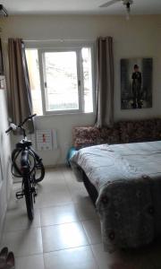 a bedroom with a bike parked next to a bed at Apartamento Praia Santos in Santos