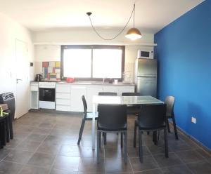 a kitchen with a table and chairs and a blue wall at Departamentos Esperanza in Colón