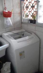 a washing machine in a bathroom with a window at Apartamento Praia Santos in Santos