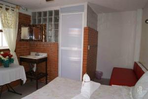 une petite salle de bain avec un lit et un lavabo dans l'établissement Hotel El Refugio, à Tlaxcala de Xicohténcatl