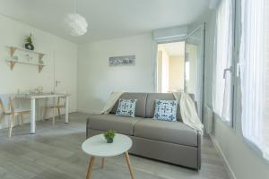 a living room with a couch and a table at Le Jardin Bleu - Dormiratoulouse Basso Cambo in Toulouse