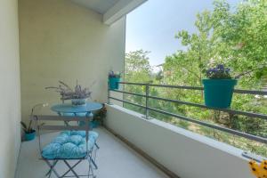 a balcony with a table and a window with plants at Le Jardin Bleu - Dormiratoulouse Basso Cambo in Toulouse