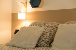 a bedroom with a bed with two pillows and a lamp at Le Jardin Bleu - Dormiratoulouse Basso Cambo in Toulouse