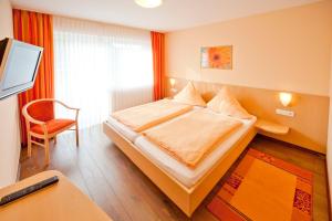 1 dormitorio con 1 cama, escritorio y TV en Landgasthof Feihl, en Oberwiesenacker