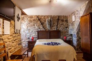 1 dormitorio con 1 cama en una pared de piedra en Castillo de Añón de Moncayo, en Añón