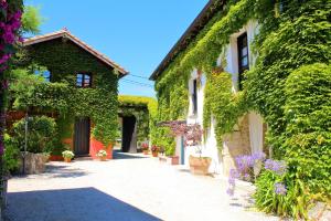 un callejón con flores y edificios cubiertos de hiedra en La Casona de Suesa, en Suesa