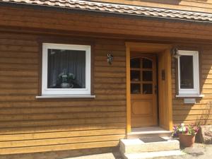 a wooden house with a door and a window at Lillys Ferienhaus in Sankt Andreasberg