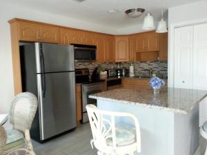 a kitchen with wooden cabinets and a stainless steel refrigerator at 1+1 Large condo Sarasota in Sarasota