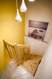 une chaise en bois dans une chambre aux murs jaunes dans l'établissement Apartment Koper, à Koper