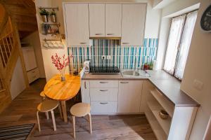 małą kuchnię z drewnianym stołem i krzesłami w obiekcie Apartment Koper w Koprze
