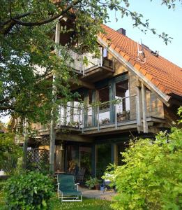 une grande maison avec une terrasse et des chaises dans la cour dans l'établissement Silvia Krafts Bed and Breakfast, à Schallstadt