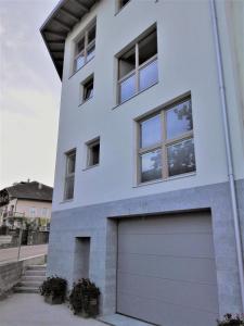 a white house with a garage at NonSoloMele in Romallo