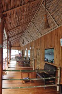 a room with benches and tables in a building at Mek Kiri Riverkwai Resort SHA in Thong Pha Phum