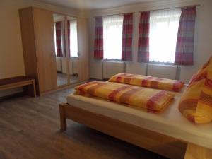 1 dormitorio con 2 camas y espejo en Ferienhof am Mitterberg, en Bad Birnbach