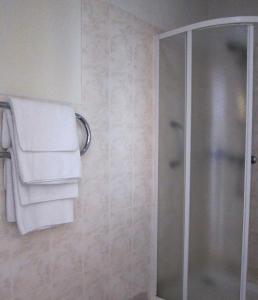 a bathroom with a shower and white towels at Hotel Vilmaja in Rīga