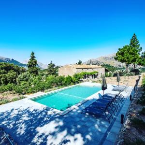 a swimming pool with chairs and a house at Agroturismo Son Alzines in Lluc