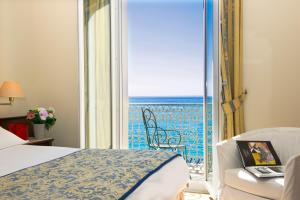 a hotel room with a bed and a view of the ocean at Hôtel West End Promenade in Nice
