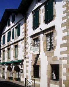 un edificio con ventanas verdes y un cartel en él en Hotel Arocena, en Saint-Pée-sur-Nivelle