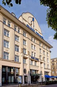 a large building with a sign on top of it at Seaside Park Hotel Leipzig in Leipzig