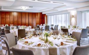 a banquet room with white tables and chairs at Seaside Park Hotel Leipzig in Leipzig