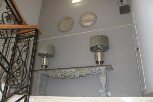 a table with two lamps and two mirrors on a wall at Hotel Villa Maria in Cabra