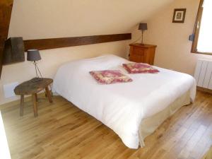 a bedroom with a white bed with two pillows on it at Ferme du Mouton Noir in Lautenbachzell