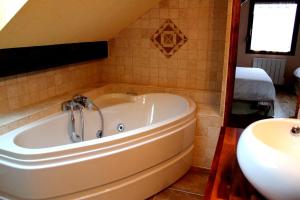 a bath tub in a bathroom with a sink at Ferme du Mouton Noir in Lautenbachzell